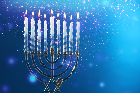 Hanukkah celebration. Menorah with burning candles on blue background, closeup. Space for textの写真素材