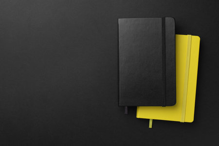 Different notebooks on black background, top view. Space for textの写真素材
