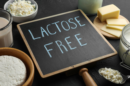 Dairy products and board with phrase Lactose free on black textured tableの写真素材