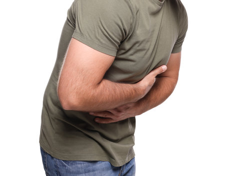 Man suffering from stomach pain on white background, closeupの写真素材