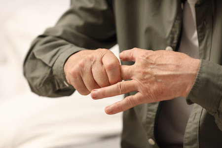 Senior man suffering from pain in hand on blurred background, closeup. Rheumatism symptomの写真素材