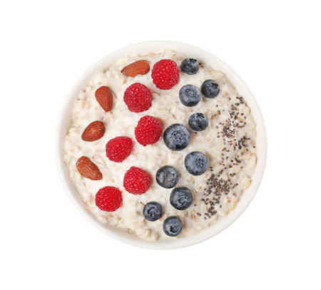 Tasty boiled oatmeal with berries, almonds and chia seeds in bowl isolated on white, top viewの写真素材