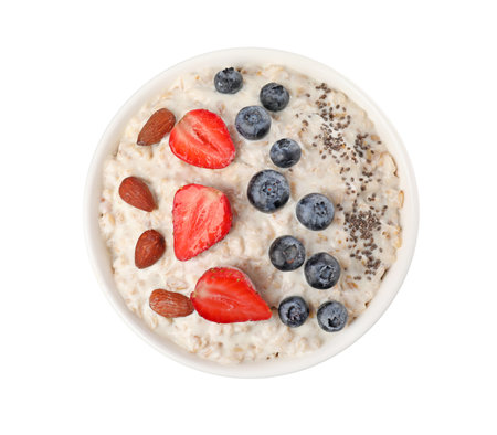 Tasty boiled oatmeal with berries, almonds and chia seeds in bowl isolated on white, top viewの写真素材