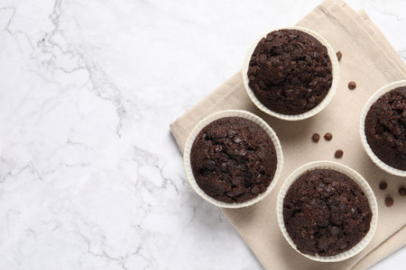 Tasty chocolate muffins on white marble table, top view. Space for textの写真素材