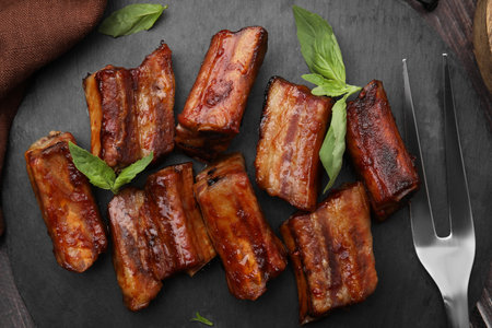 Tasty roasted pork ribs served on slate plate, flat layの写真素材