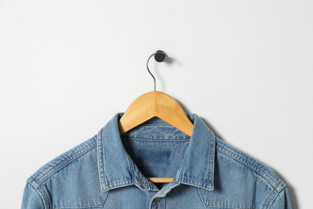 Hanger with denim shirt on white wallの写真素材