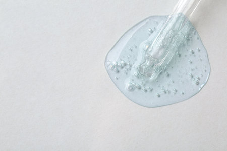 Pipette with cosmetic serum on white background, top view. Space for textの写真素材