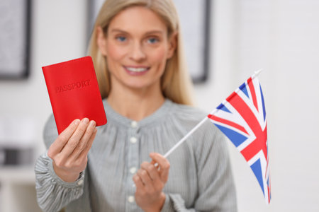 Immigration. Happy woman with passport and flag of United Kingdom indoors, selective focusの写真素材