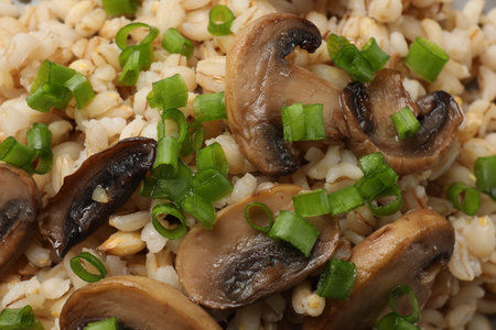 Delicious pearl barley with onion and mushrooms as background, closeupの写真素材