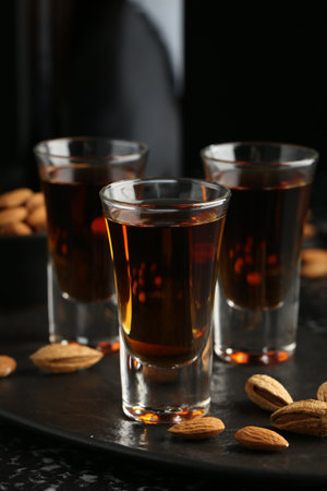 Glasses with tasty amaretto liqueur and almonds served on table, closeupの写真素材