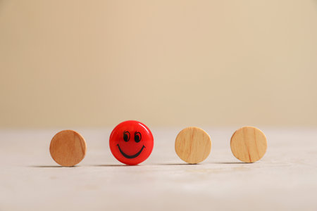 Choice concept. Red magnet with happy emoticon among wooden circles on light tableの写真素材