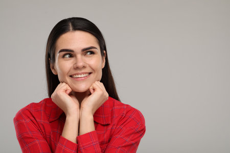 Young woman with clean teeth smiling on light gray background. Space for textの写真素材