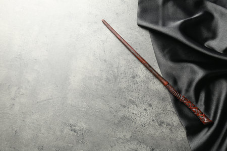 Magic wand and dark cloth on light gray background, top view. Space for textの写真素材