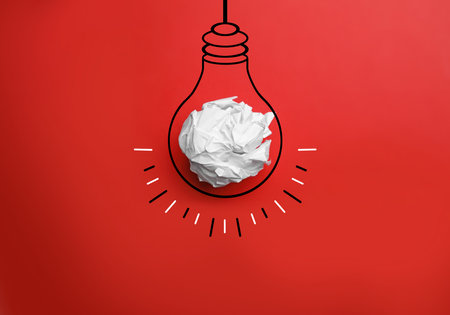 Idea. Illustration of light bulb around crumpled paper ball on red background, top viewの写真素材