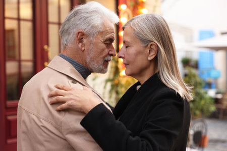 Affectionate senior couple dancing together on city street