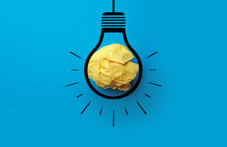 Idea. Illustration of light bulb around crumpled paper ball on light blue background, top viewの写真素材