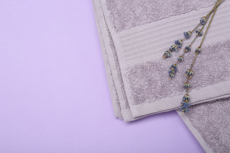 Terry towel and lavender flowers on violet background, top view. Space for textの写真素材