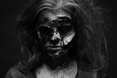 Scary zombie on dark background, black and white effect. Halloween monster