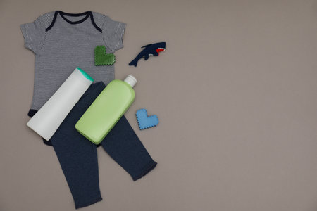 Bottles of laundry detergents, baby clothes, toy shark and decorative hearts on gray background, flat lay. Space for textの写真素材