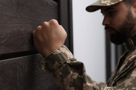 Military commissariat representative knocking on wooden door, selective focusの写真素材