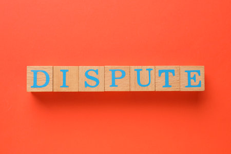 Word Dispute made with wooden cubes on red background, top view