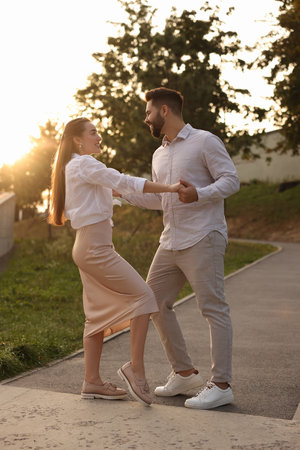 Lovely couple dancing together outdoors at sunsetの写真素材