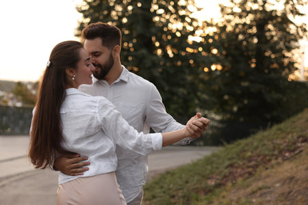 Lovely couple dancing together outdoors, space for text. Romantic date