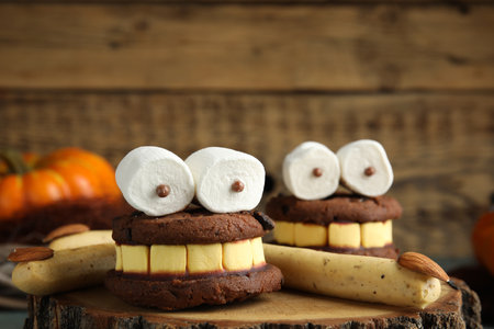 Delicious desserts decorated as monsters on stump, closeup. Halloween treatの写真素材