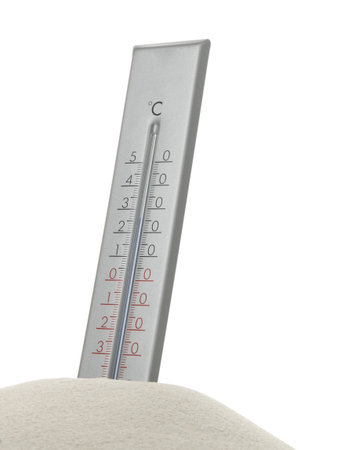 Weather thermometer in sand against white background