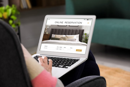 Man using laptop to book hotel at home, closeupの写真素材