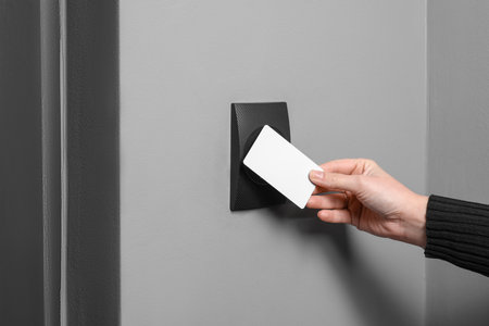 Woman opening magnetic door lock with key card, closeup. Home securityの写真素材