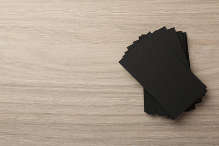 Blank black business cards on wooden table, top view. Mockup for design
