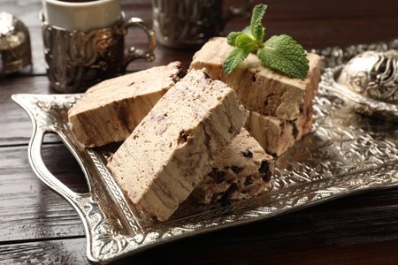 Tasty chocolate halva and mint on wooden table, closeup