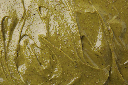 Tasty pistachio cream as background, top view