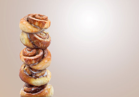 Cinnamon rolls balancing on light greyish brown background, space for textの写真素材
