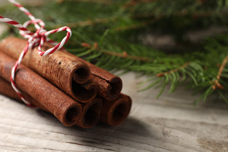 Cinnamon sticks and fir branches on wooden table, closeupの写真素材