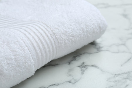 Folded terry towel on white marble table, closeup. Space for textの写真素材