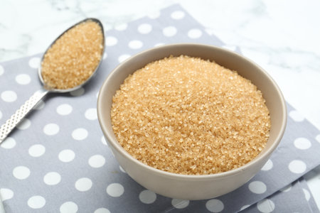 Brown sugar in bowl and spoon on table, closeupの写真素材