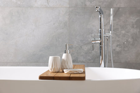Set of bath accessories on tub in bathroom