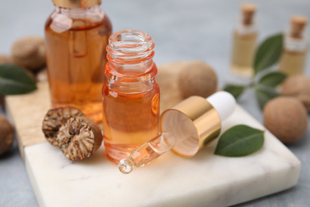 Nutmeg essential oil and nuts on tableの写真素材