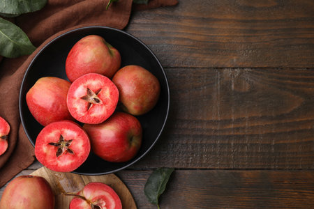 Tasty apples with red pulp and leaves on wooden table, flat lay. Space for textの写真素材