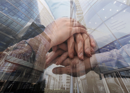 Partnership concept. Double exposure of people joining hands together and cityscape.の写真素材