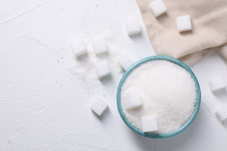 Different types of sugar in bowl on white table, flat lay. Space for textの写真素材