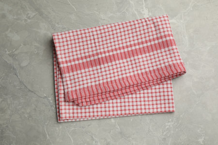 Red checkered kitchen towel on gray table, top view