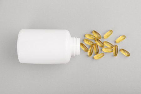 Bottle and vitamin capsules on light gray background, top viewの写真素材