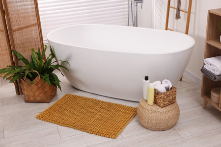 Stylish bathroom interior with soft bath mat and tubの写真素材