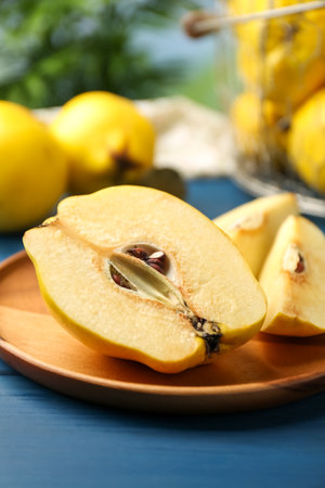 Tasty ripe quince fruits and knife on blue wooden table, closeupの写真素材