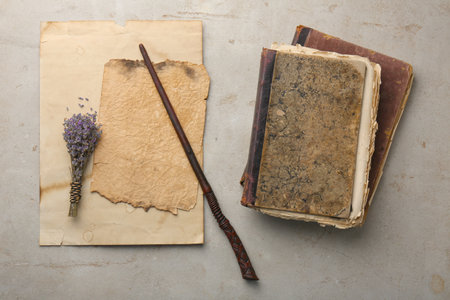 Magic wand, lavender flowers, old books and papers on light textured background, flat layの写真素材