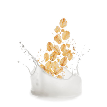 Rolled oats falling into splashing milk on white backgroundの写真素材