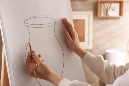 Woman drawing vase with graphite pencil on canvas indoors, closeupの写真素材